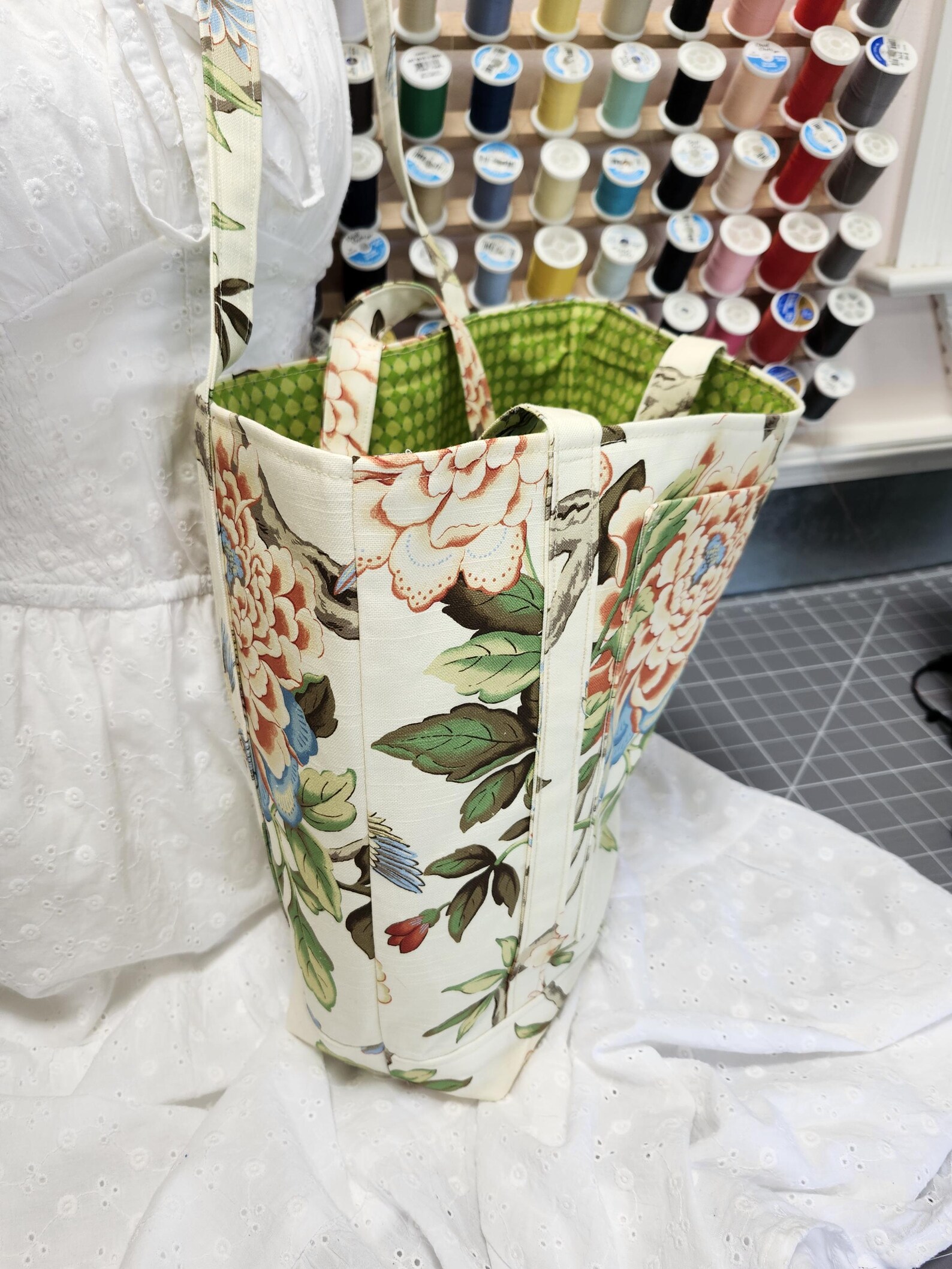Bolsa de tela floral cosida a mano junto a sus hilos de colores